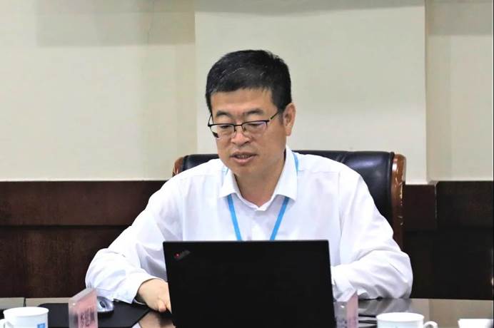 男人拿著筆記本電腦的桌子前描述已自動(dòng)生成